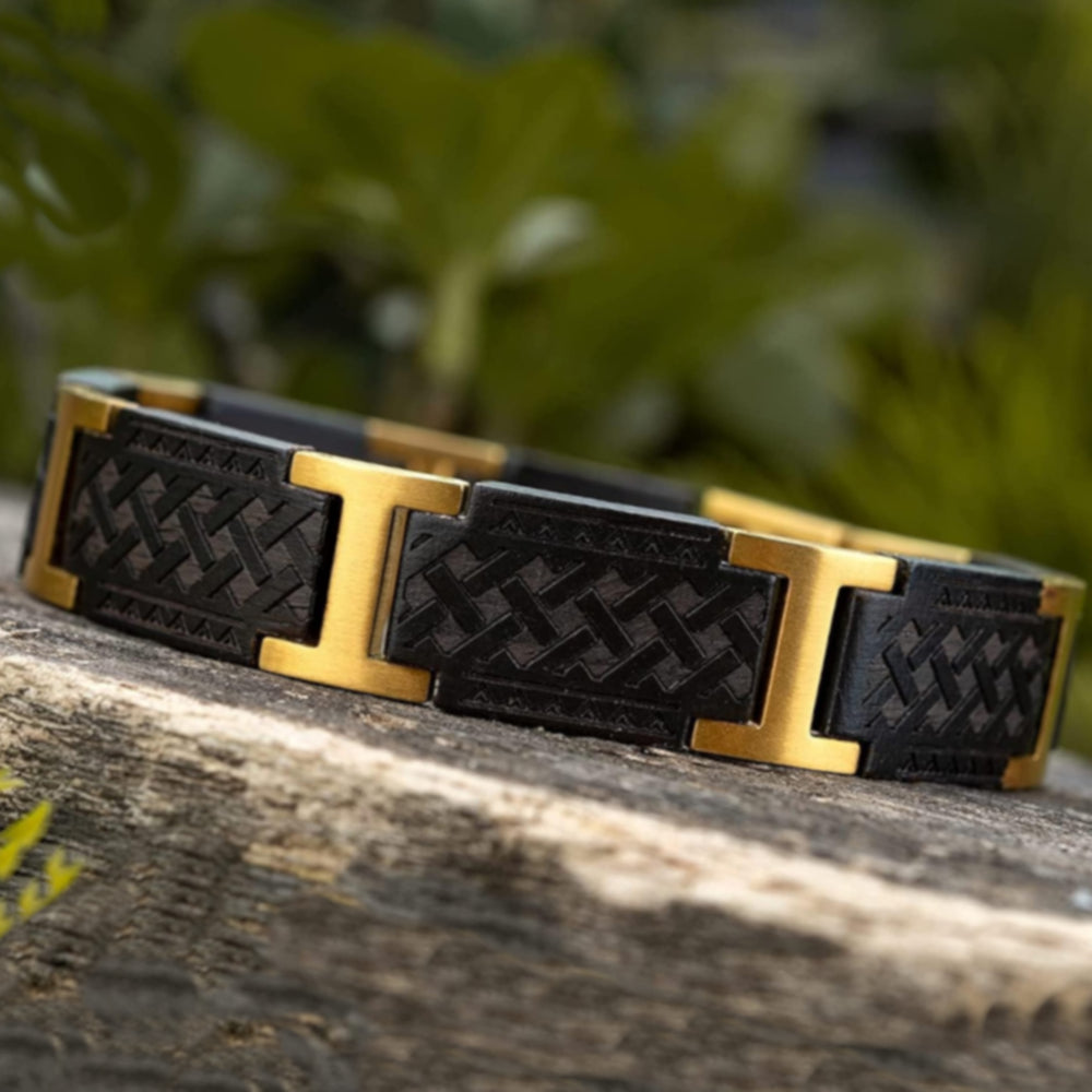Lifestyle Foto des Holzwerk BALKSEE Armbands aus Ebonyholz und Edelstahl in Gold und Schwarz auf Holz