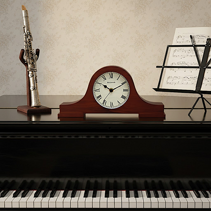 Holzwerk BRAUBACH Retro-Tischuhr  aus dunklem Walnussholz mit cremeweißem Zifferblatt und römischen Ziffern auf dem Klavier