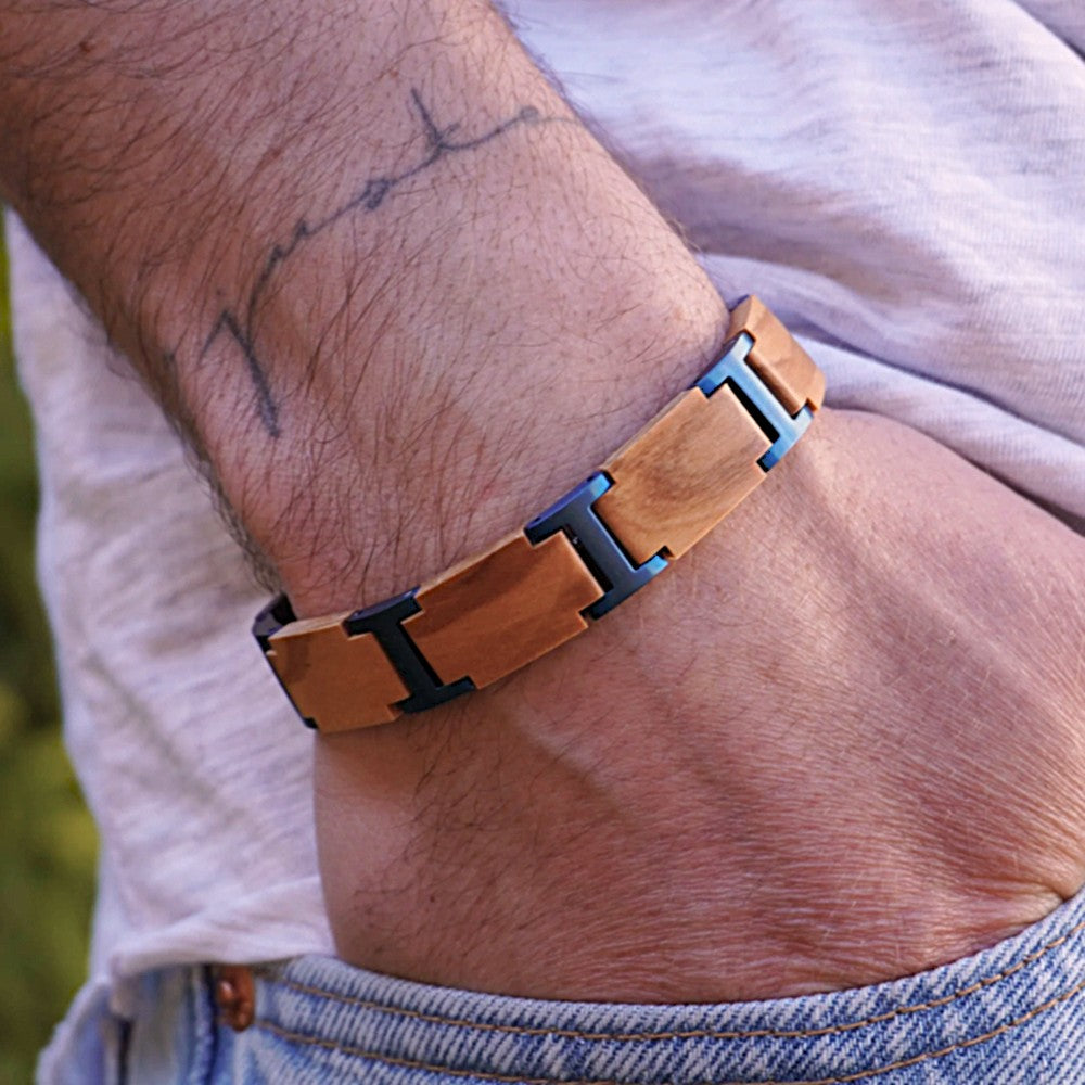 Holzwerk ELBSEE Armband aus Olivenholz und Edelstahl in Blau und Beige mit Gliederdesign am Handgelenk getragen
