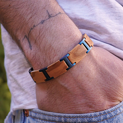 Holzwerk ELBSEE Armband aus Olivenholz und Edelstahl in Blau und Beige mit Gliederdesign am Handgelenk getragen
