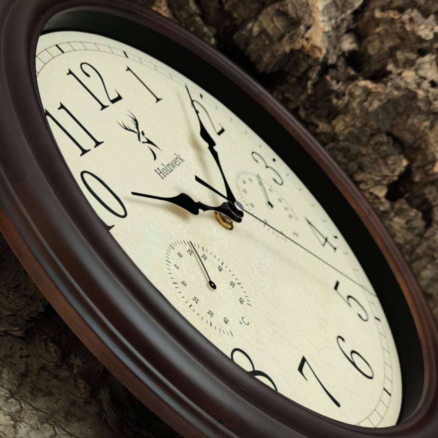 Schrägansicht der Holzwerk HORNBERG 35 cm Vintage Quarz-Wanduhr mit Fokus auf dem beigem Ziffernblatt und der Zeigerführung