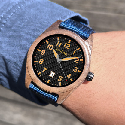 Holzwerk SYLT Unisex Uhr aus Holz mit schwarz-orangenem Zifferblatt, Datum und blauem Textil-Nylonarmband am Handgelenk getragen